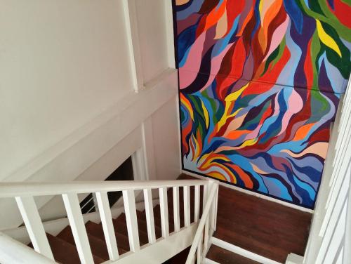 eine Treppe mit farbenfrohem Gemälde an der Wand in der Unterkunft Dormitels.ph The Fort BGC in Manila