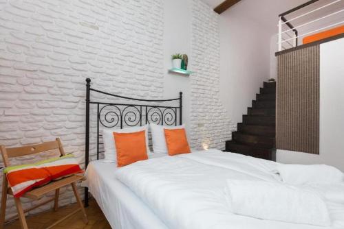 a bedroom with a large white bed with orange pillows at Urban Nest Apartments Dietla 69-8B in Krakow