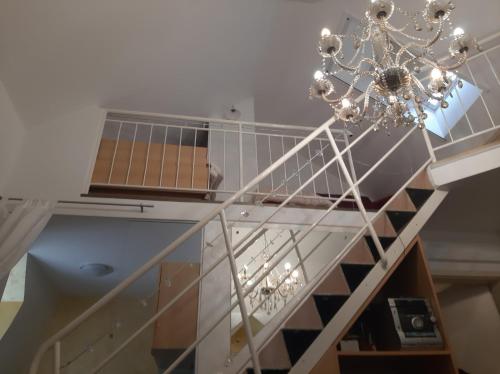 a staircase with a chandelier in a room at VILLA GOLF Crystal Drop Apartment in Rogaška Slatina