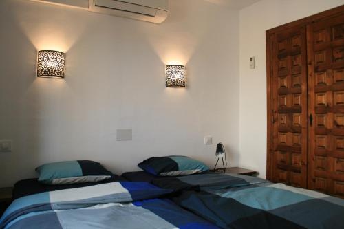 ein Schlafzimmer mit zwei Betten und zwei Lampen an der Wand in der Unterkunft Casa León with private pool great view in Benissa