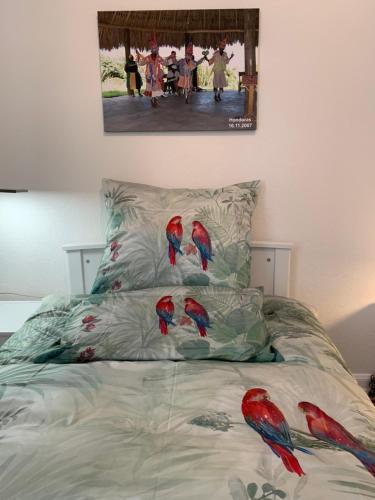 a bed with three red parrots on it at Remedium Appartements in Vlotho