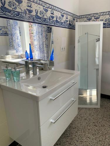 a white bathroom with a sink and a mirror at Remedium Appartements in Vlotho