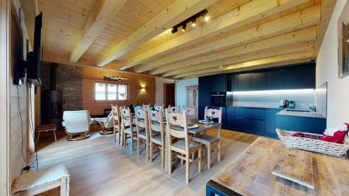 a kitchen and dining room with a table and chairs at Chalet des Alpes NATURE & MOUNTAIN by Alpvision Résidences in Prarion