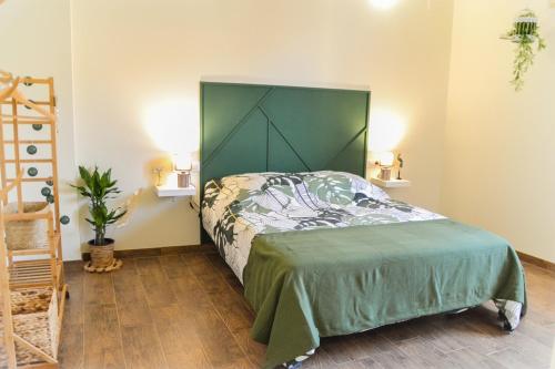 a bedroom with a bed with a green headboard at Casa Bienvenida - La Naturaleza in Carcagente