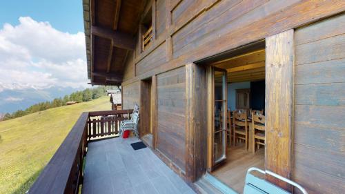 a balcony of a wooden building with a table and chairs at Chalet des Alpes NATURE & MOUNTAIN by Alpvision Résidences in Prarion