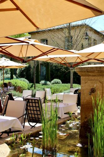 a patio with tables and chairs and umbrellas at Villa Saint-Ange in Aix-en-Provence
