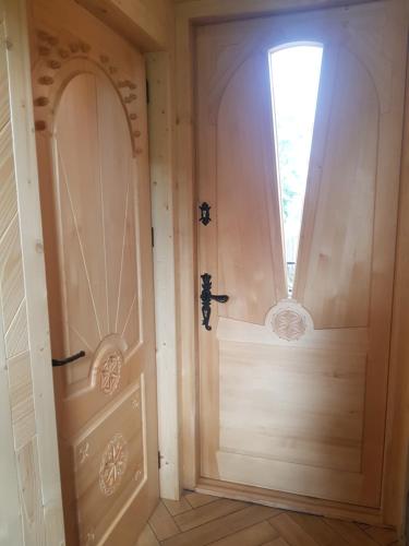 Una puerta de madera en una habitación con ventana en Apartamenty BENITA, en Zakopane