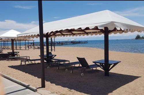 a group of chairs and umbrellas on a beach at Deluxe Royal Beach in Chok-Tal