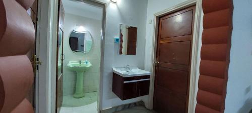 łazienka z umywalką, toaletą i drzwiami w obiekcie Jinan palace guest house Jinan palace guest house w mieście Nedumbassery
