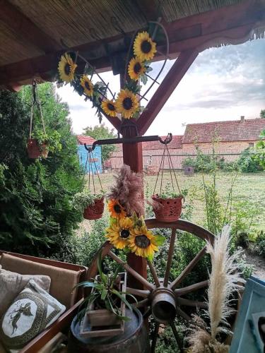 a wagon wheel with sunflowers on it in a yard at Etno kuća Teodora in Staji°evo