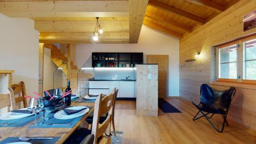 a dining room with a long table and chairs at Chalet des Alpes NATURE & MOUNTAIN by Alpvision Résidences in Prarion