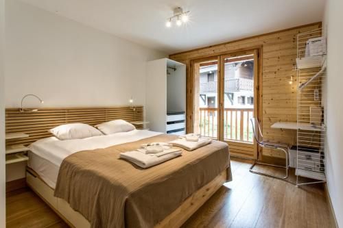 a bedroom with a large bed and a window at Apartment Chalet des Granges in Les Houches