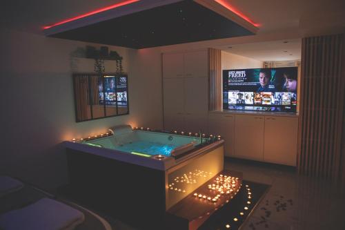 La salle de bains est pourvue d'une baignoire et d'une télévision en arrière-plan. dans l'établissement L&H SUIT, au Havre