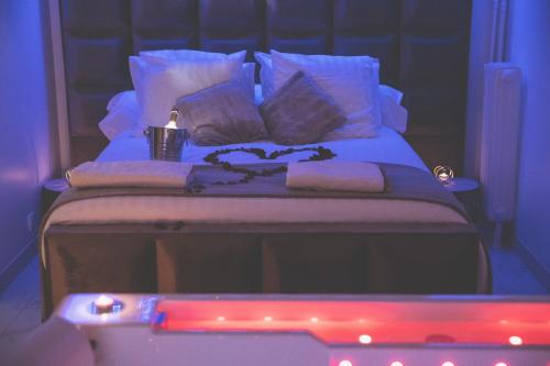 Una cama con almohadas blancas y una vela. en L&H SUIT, en Le Havre