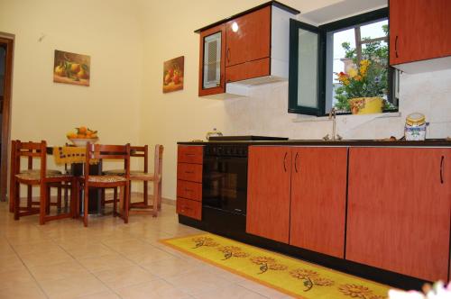 a kitchen with a black stove and a table at Albicocche House in Giarre