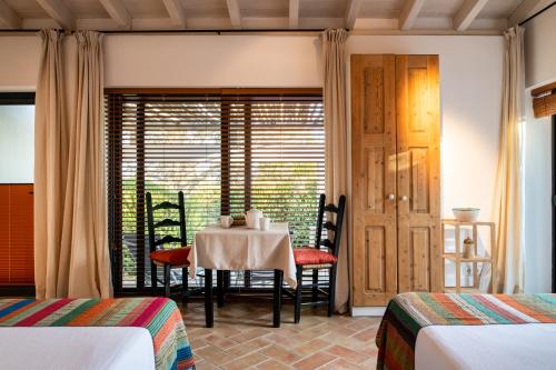a dining room with a table and a window at Altanure Casa Terra - Ecological Boutique Stay in Tavira