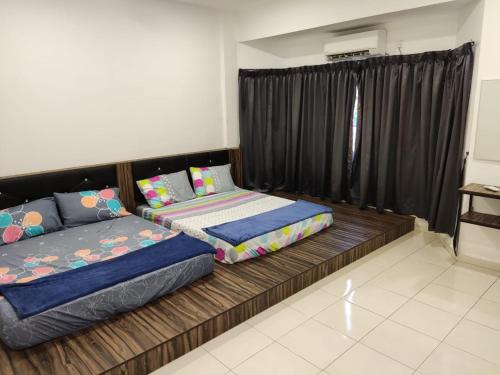 two beds in a room with black curtains at Homestay 112 in Ipoh