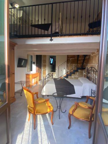 a living room with a bed and a table and chairs at Morfeo Charming Rooms & Relax in Avola