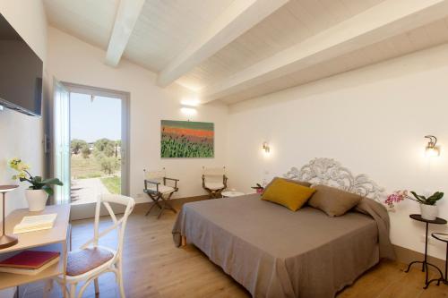 a bedroom with a bed and a desk and a window at Casale Oliveta in Orbetello