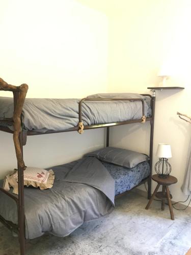 a bedroom with two bunk beds and a lamp at Garola Coccodè 2 in Luserna San Giovanni