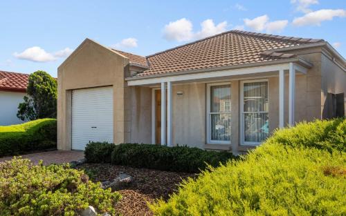 a house with a garage and bushes at Lakeside Haven in Encounter Bay