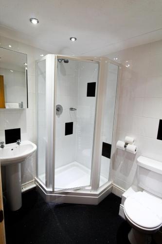 a bathroom with a shower and a toilet and a sink at The Heritage Hotel in Torquay