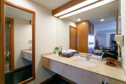 a bathroom with a sink and a mirror at Amora Thapae Hotel Chiang Mai in Chiang Mai