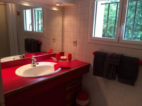 a bathroom with a red sink and a mirror at Guest house Maison Iratzean in Ascain