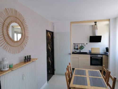 a kitchen and dining room with a table and a mirror at Appartement centre ville avec parking privatif in Dijon