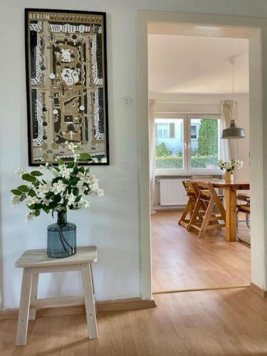 a living room with a table and a vase of flowers at Villa Rosa in Bad Sachsa