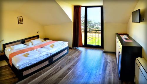 a bedroom with a bed and a large window at Agancsos Panzió Villány in Villány