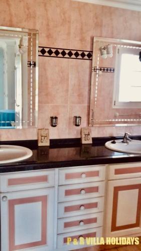 a bathroom with two sinks and a large mirror at Villa Can Pere Cala Galdana Menorca in Cala Galdana