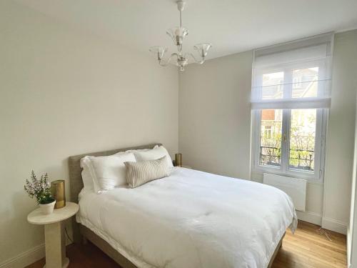 a bedroom with a white bed and a window at Petit Vert Epernay in Épernay