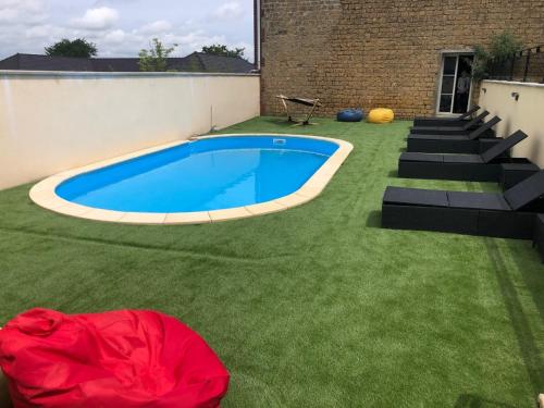 une cour avec une piscine et de l'herbe verte dans l'établissement Les villas d'Hannogne, à Hannogne-Saint-Martin