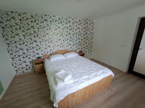 a bedroom with a bed with a floral wallpaper at Casa NICHIFOR Jurilovca in Jurilovca