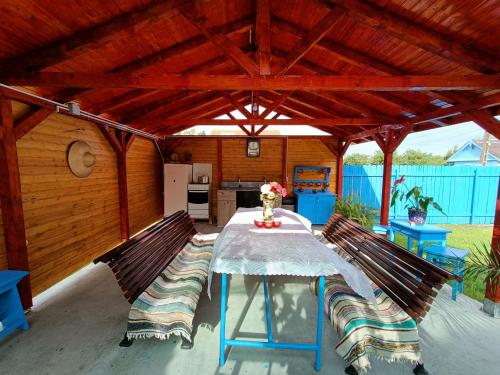 a wooden pavilion with a table and two benches at Casa NICHIFOR Jurilovca in Jurilovca