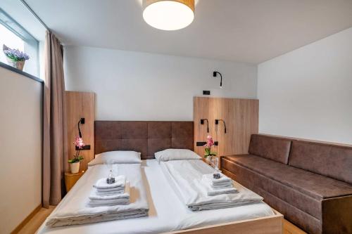 a bedroom with a large bed and a couch at Sunny Ferienwohnungen Ski In - Ski Out - Self Check-in in Zell am See
