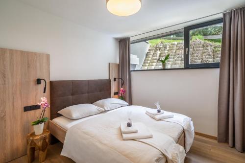 a bedroom with a bed with two towels on it at Sunny Ferienwohnungen Ski In - Ski Out - Self Check-in in Zell am See