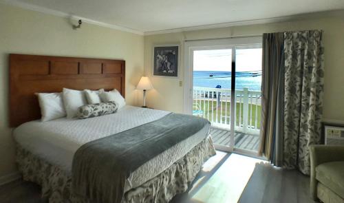 a bedroom with a bed and a balcony with the ocean at Sunrise Motel in York
