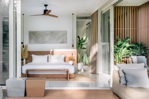 a bedroom with a bed and a couch at Anaia in Thongsala