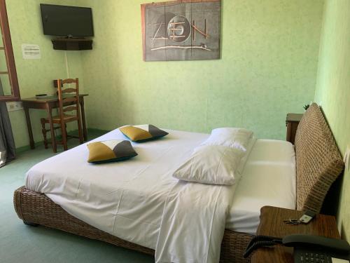 a bedroom with a bed with white sheets and yellow pillows at Le Richelieu in Saint-Jean-de-Monts