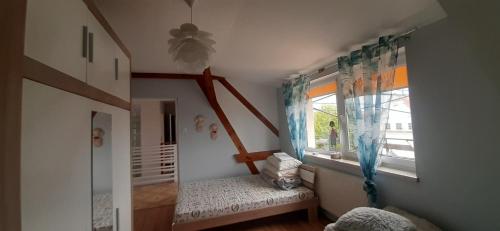 a childs room with a window and a bench at Mazurskie Wzgórze Dom Wakacyjny in Rydzewo