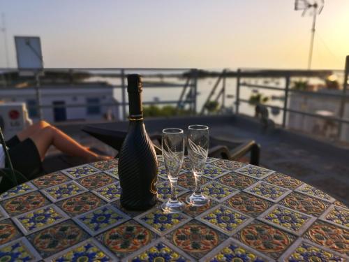 a bottle of wine sitting on a table with glasses at Salento Sea & Sun Apartment in Porto Cesareo