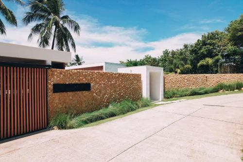 a brick wall next to a driveway at Anaia in Thongsala