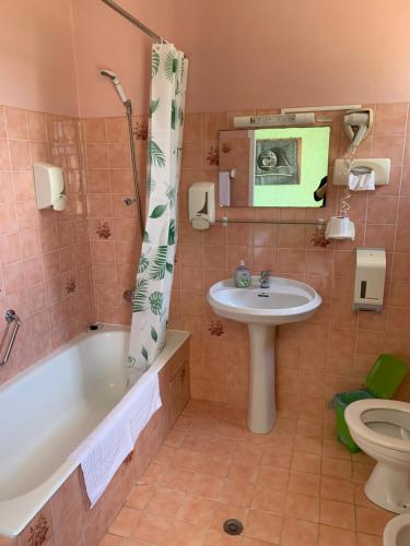 łazienka z wanną, umywalką i toaletą w obiekcie Le Richelieu w mieście Saint-Jean-de-Monts