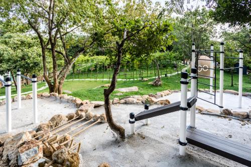 a park with a bench and a tree in it at Anaia in Thongsala