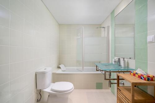タヴィラにあるUnique Coastal Cabanas de Tavira Apartmentのトイレ、シャワー、洗面台を備えたバスルーム