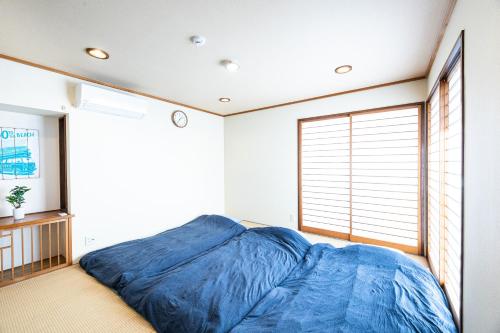a bedroom with a blue bed in a room with a window at VAMOS A VER #RK1 in Iwada