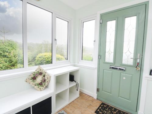 a room with a green door and windows at 6 Lowlands in Arisaig