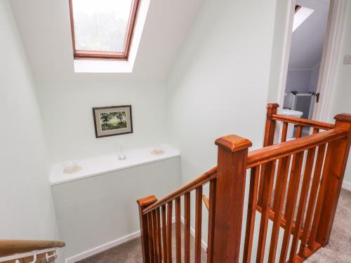 a staircase with a white wall and a window at 6 Lowlands in Arisaig